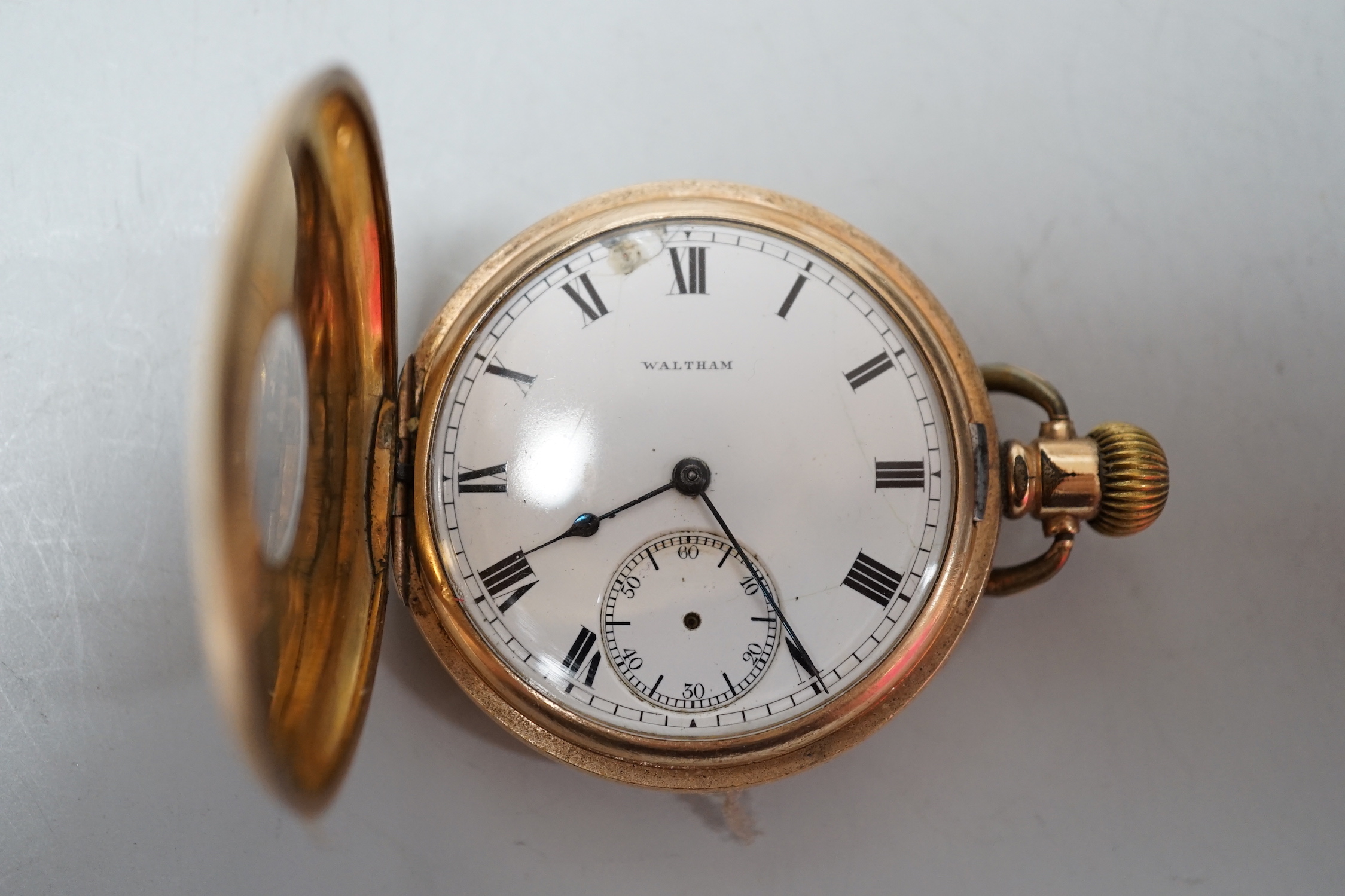 A gold plated pocket watch and carved alabaster stand, total height 14 cm